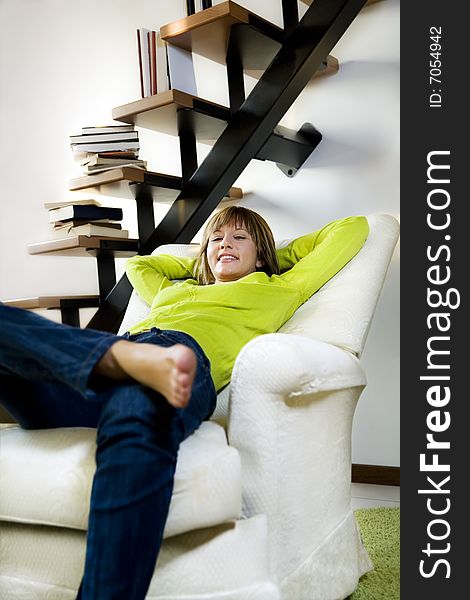 Portrait of young woman relaxing in chair at home. Portrait of young woman relaxing in chair at home