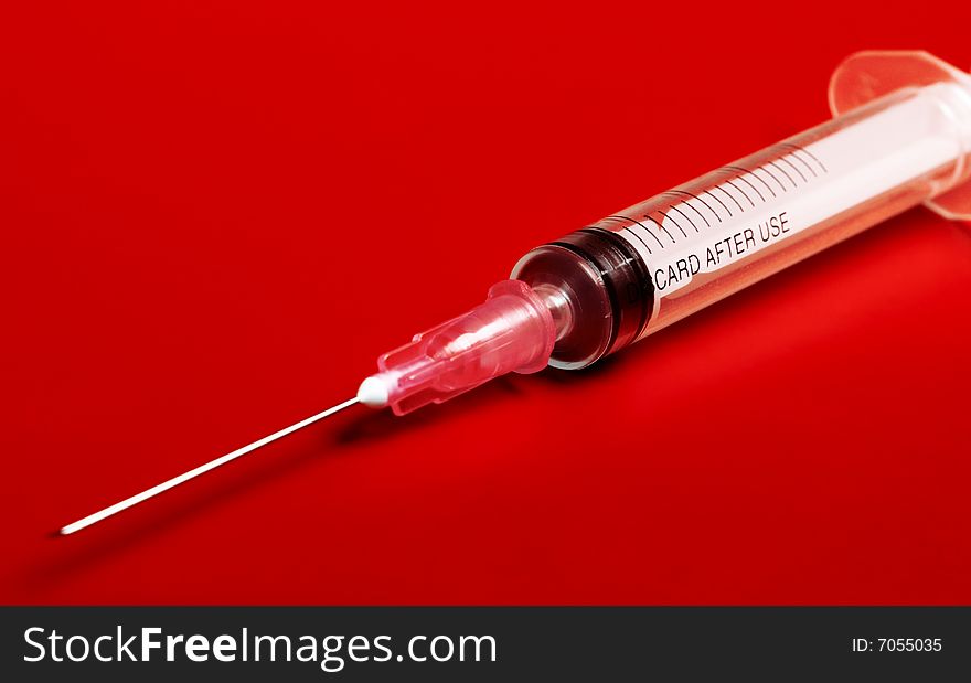 Empty red syringe on red