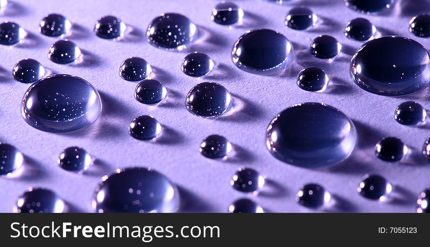 An image of water drops on violet background. An image of water drops on violet background
