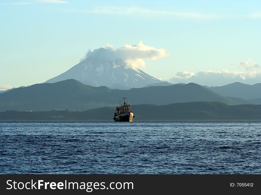 Old fishing ship on background of the vulcan