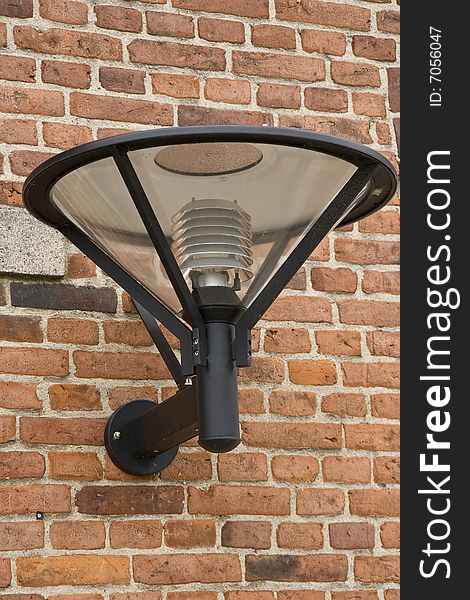 Modern outdoor lamp on red brick wall