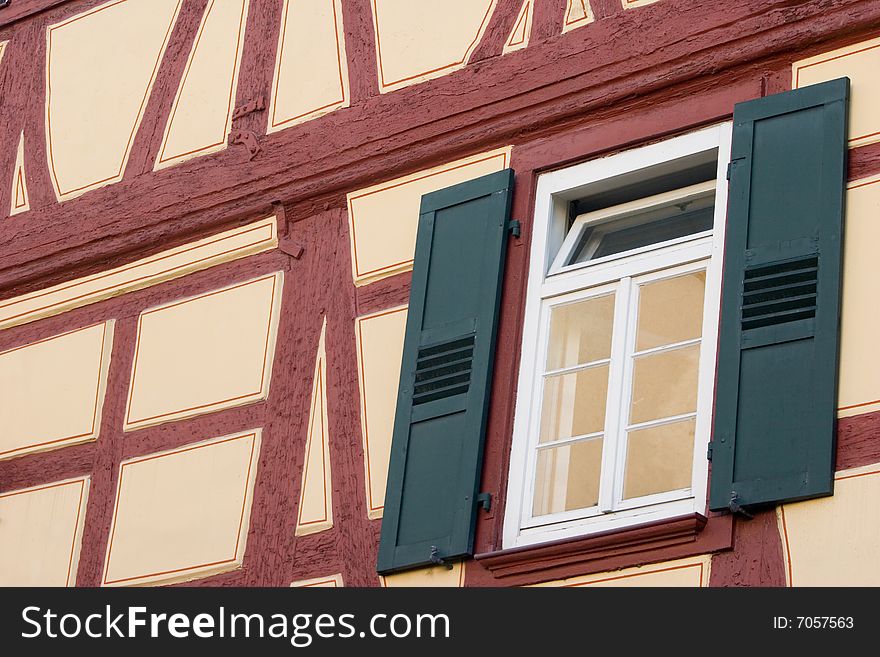 Closeup of window with green shutters on the traditional German half-timbered house wall. Closeup of window with green shutters on the traditional German half-timbered house wall