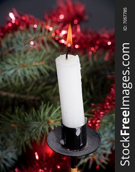 Christmas candle with flame on colored background