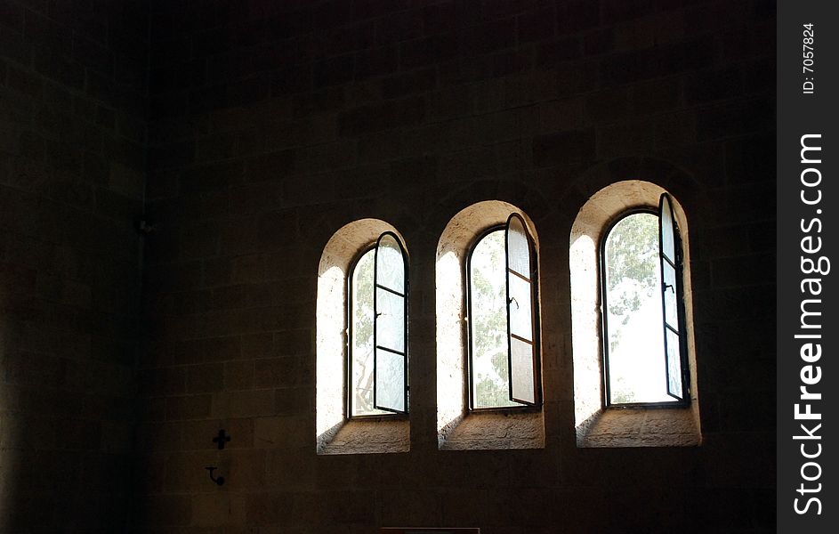 Trees discernible through the windows  in a church wall. Trees discernible through the windows  in a church wall