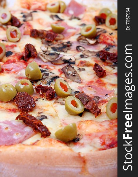 Close up , piece of pizza witk olives, dry tomatos,ham and  mushrooms