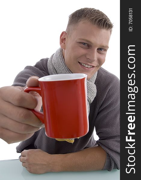 Handsome young man showing coffee mug on an isolated background