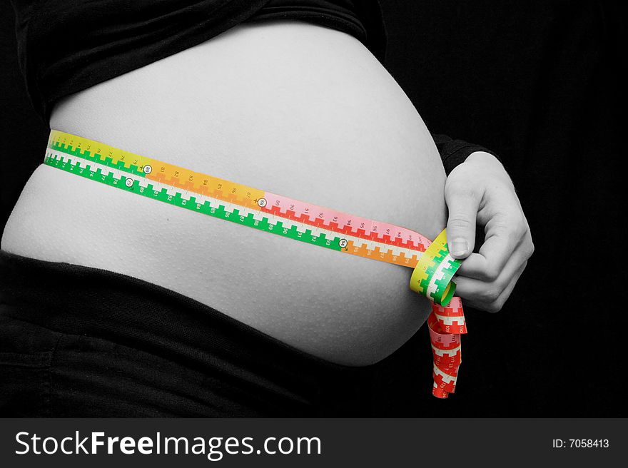 Pregnant woman measuring her stomach. Pregnant woman measuring her stomach