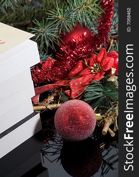 Red ball Christmas decoration on dark background with books gift. Red ball Christmas decoration on dark background with books gift