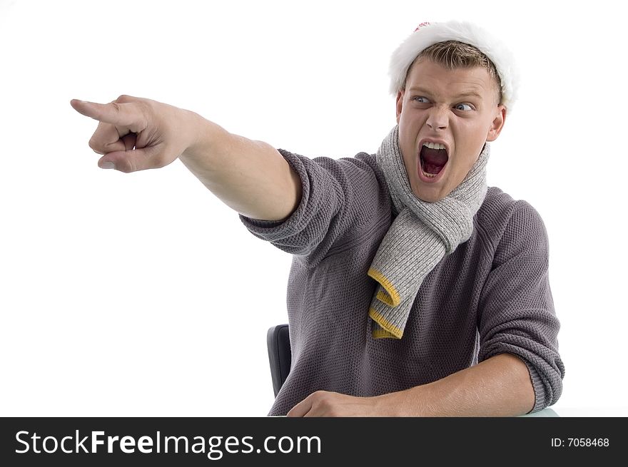 Shouting male with Christmas hat pointing aside on an isolated white background