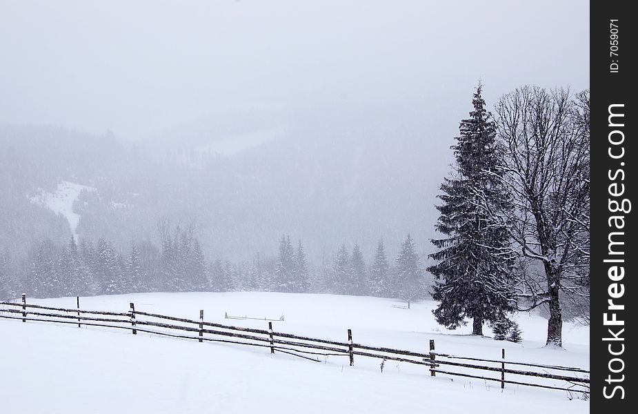 Snowy field with fence in winter mountains. Snowy field with fence in winter mountains