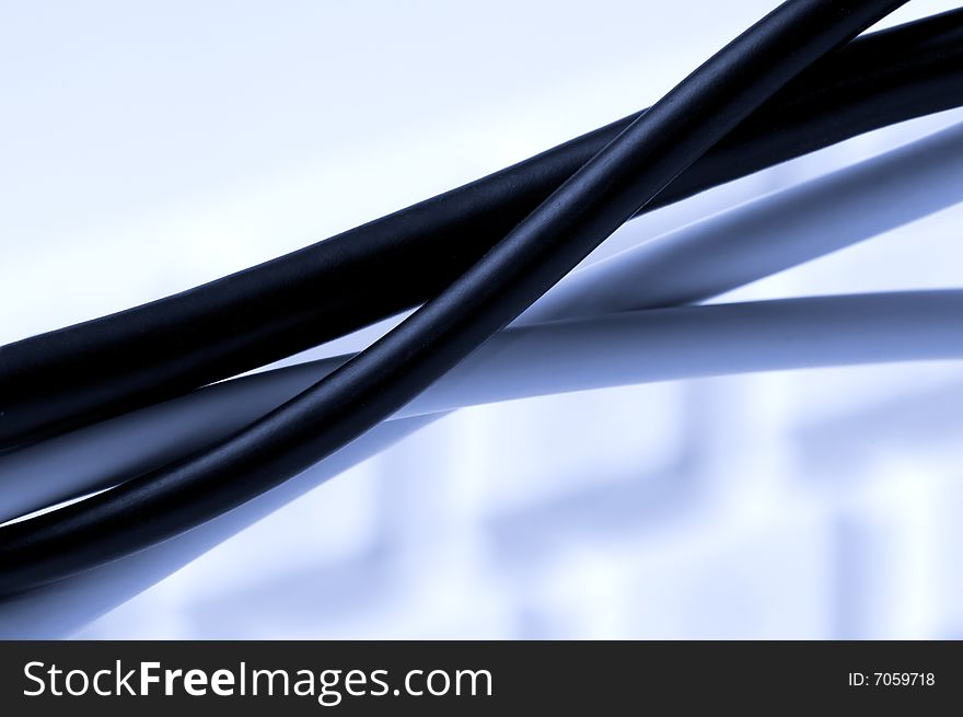 Computer cables over a blurry keyboard background. Computer cables over a blurry keyboard background