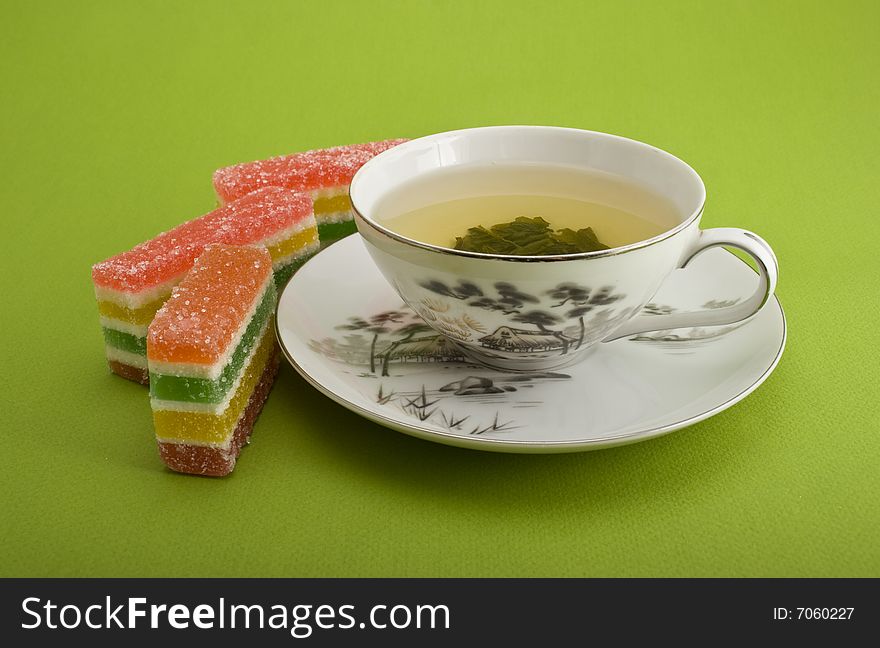 Tea cup and jellies close-up isolated