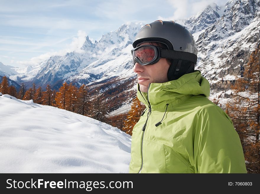 Portrait of young caucasian skier with ski goggles and helmet. on background a winter alpine landscape. Portrait of young caucasian skier with ski goggles and helmet. on background a winter alpine landscape.