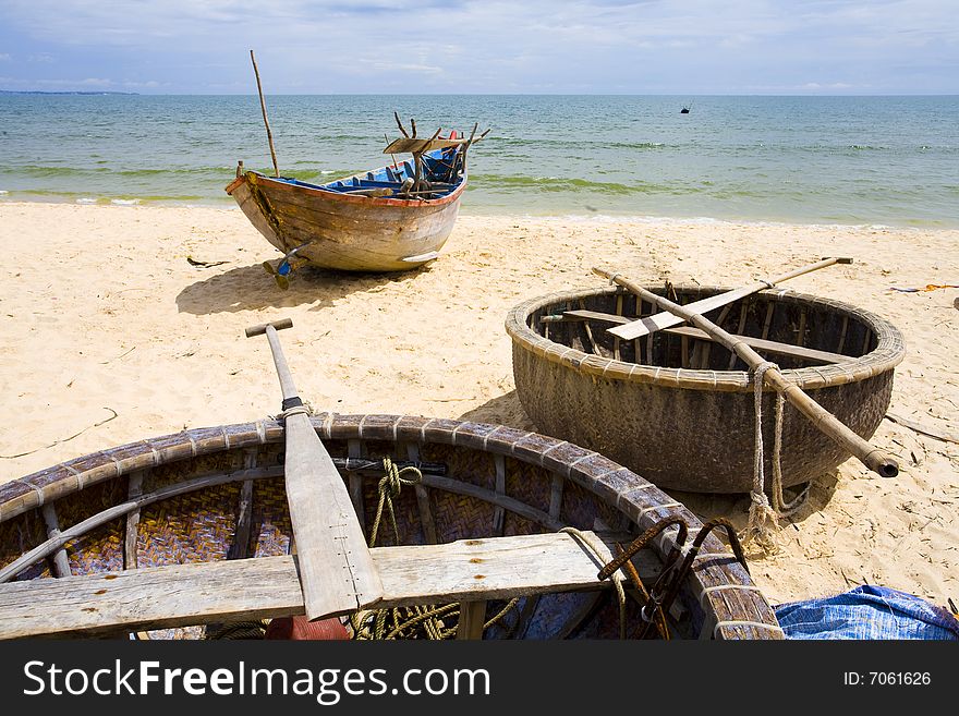 One big and two small fisher boats on sand of coastline