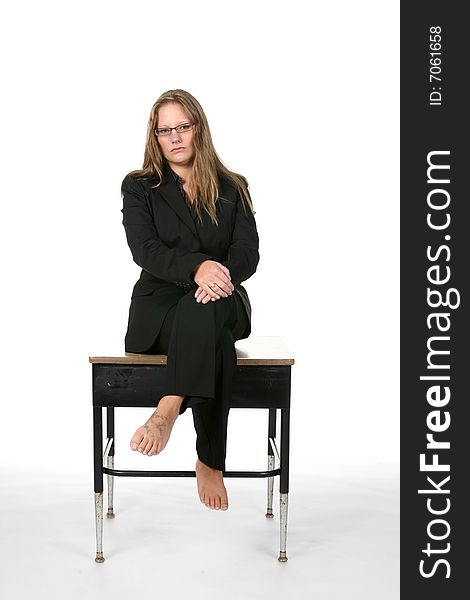 Female business person in black and bare feet on school desk. Female business person in black and bare feet on school desk