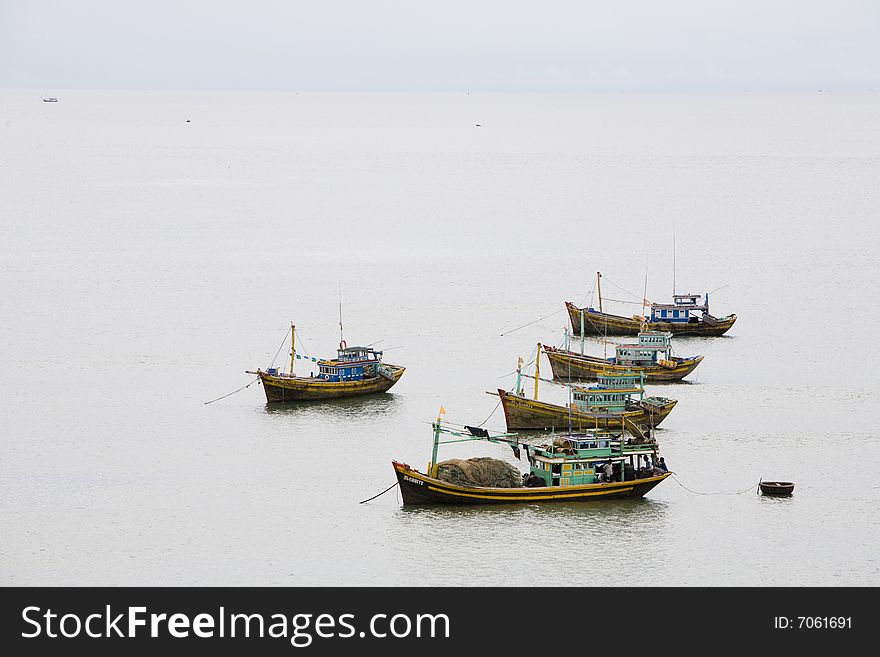 Many fisher boats in a sea at cloudy day