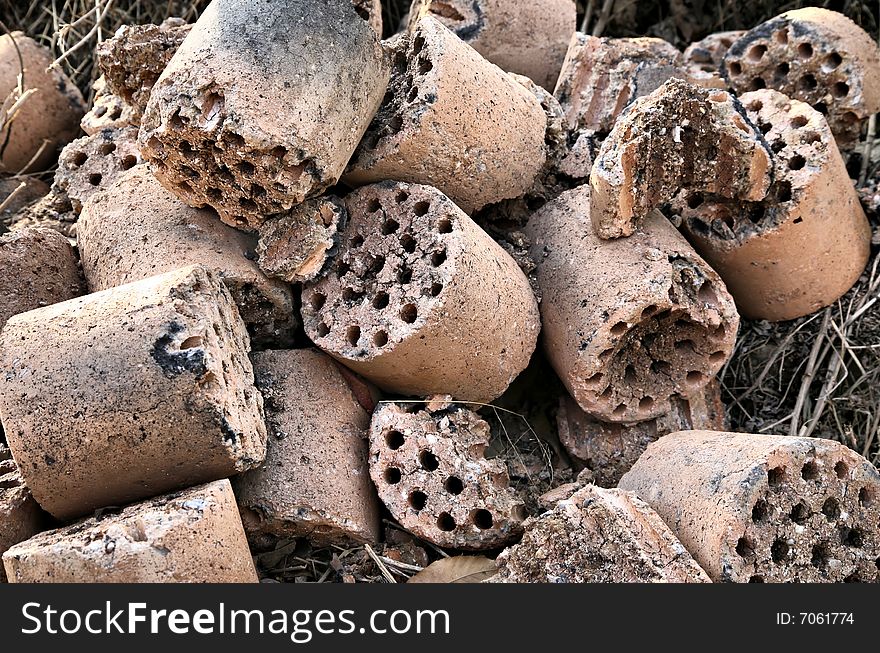 Used up spent round charcoal briquet fuel rods left on the side of road