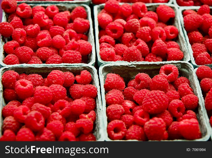 Fresh red ripe raspberries in baskets at a fruit stand. Fresh red ripe raspberries in baskets at a fruit stand