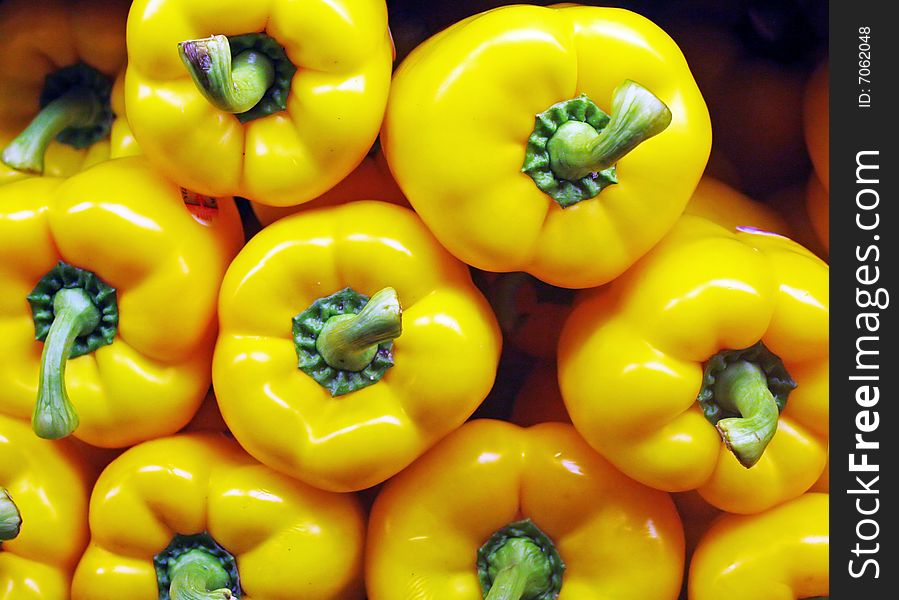 A display of yellow bell peppers in a vegetable market. A display of yellow bell peppers in a vegetable market
