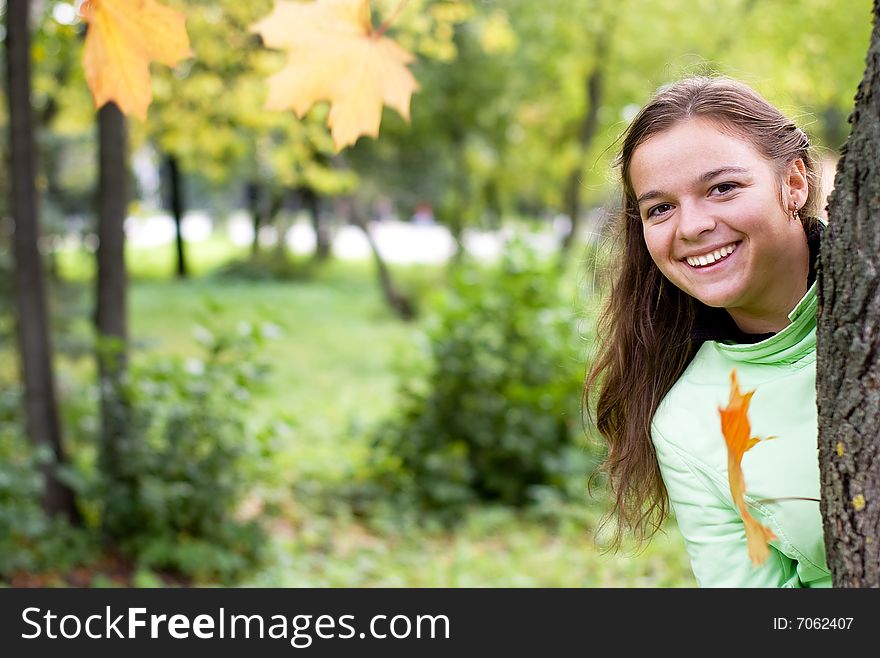 Smiling girl and falling maple leaves