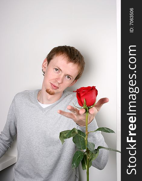 Red-haired young man holding a red rose. Red-haired young man holding a red rose