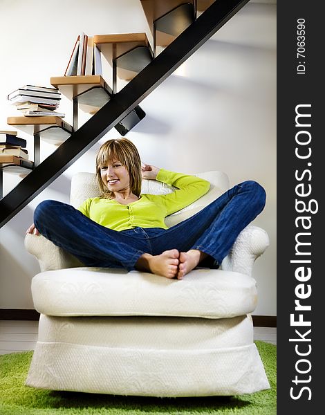 Portrait of young woman relaxing in chair at home. Portrait of young woman relaxing in chair at home