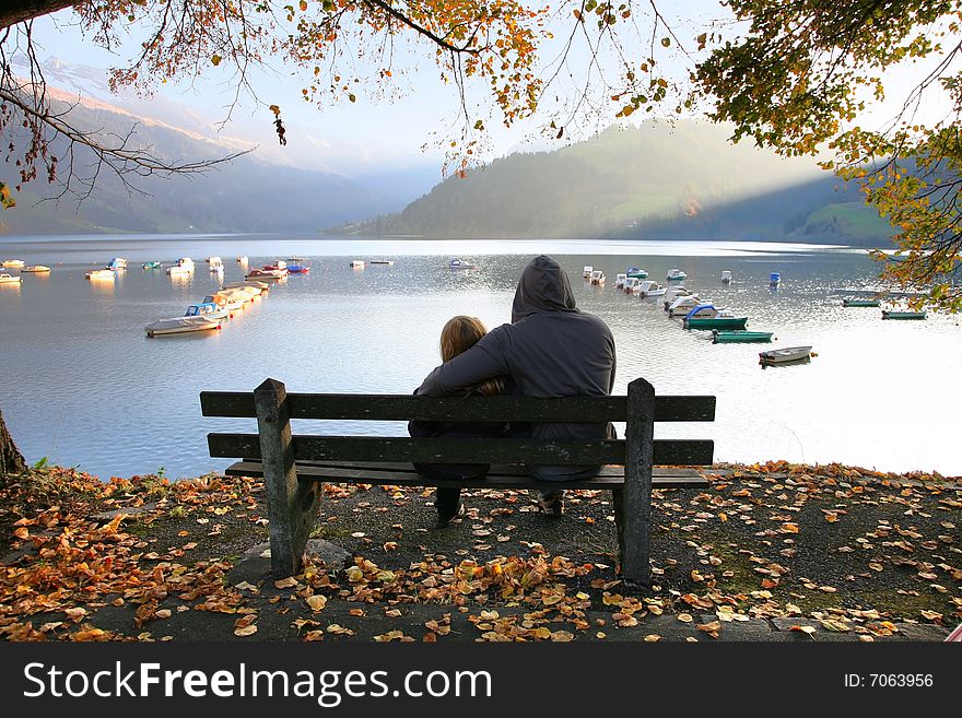 View of the lake WÃ¤gital in Swiss Alps with a family on the bench. View of the lake WÃ¤gital in Swiss Alps with a family on the bench