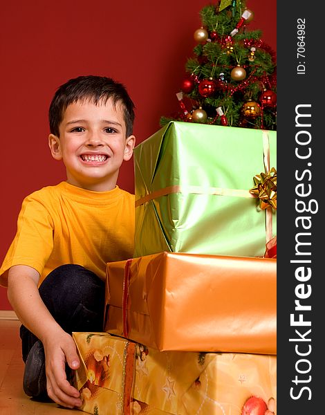 Boy in jeans and yellow top carrying three gifts tied with colourful ribbons. Boy in jeans and yellow top carrying three gifts tied with colourful ribbons..