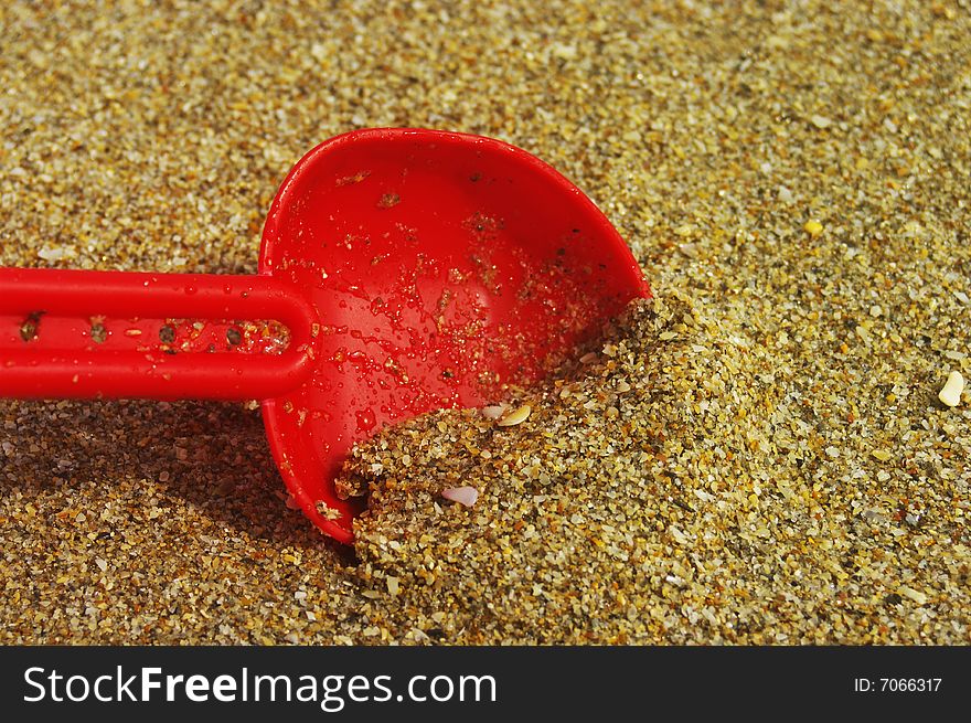 Child's toy shovel in the beach sand. Child's toy shovel in the beach sand