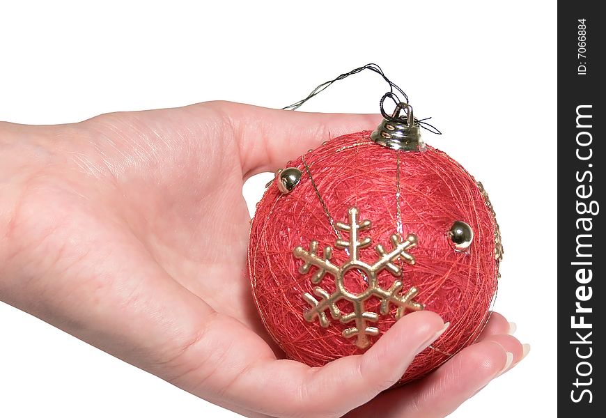 The female hand holds a Christmas ornament. Evening ball.