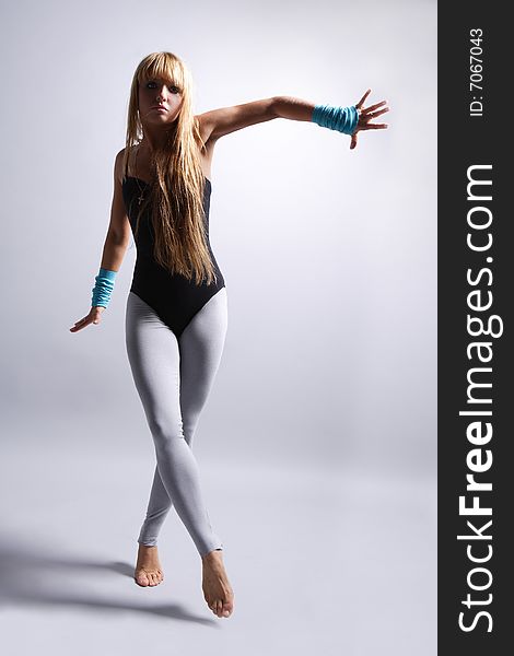 Young beautiful dancer posing on grey. Young beautiful dancer posing on grey