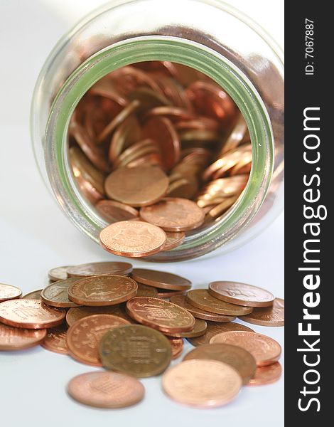 An open jar of pennies cascading from a jar. An open jar of pennies cascading from a jar