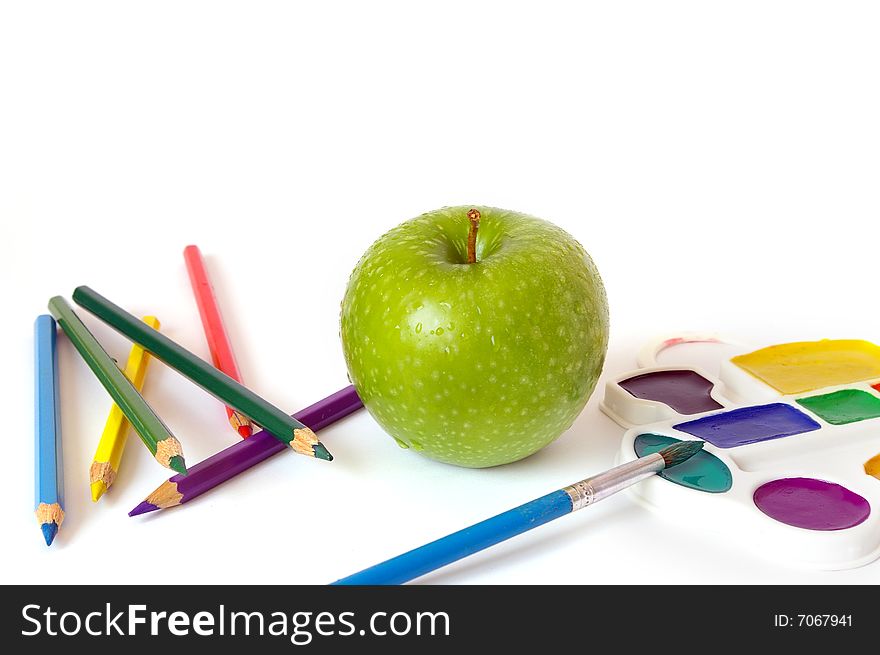 Green apple, pencils and paints isolated on white background. Green apple, pencils and paints isolated on white background