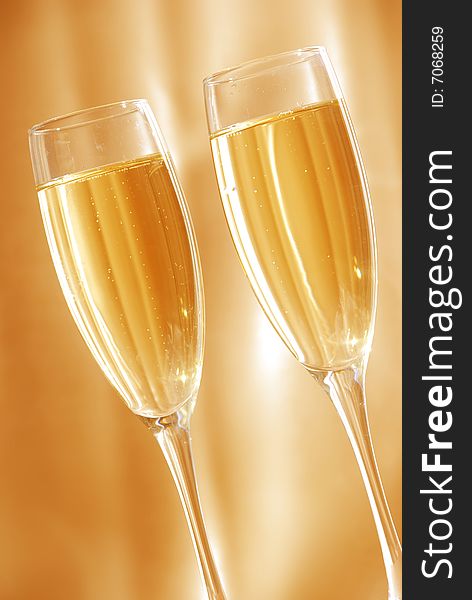 Two glasses of champagne against golden background