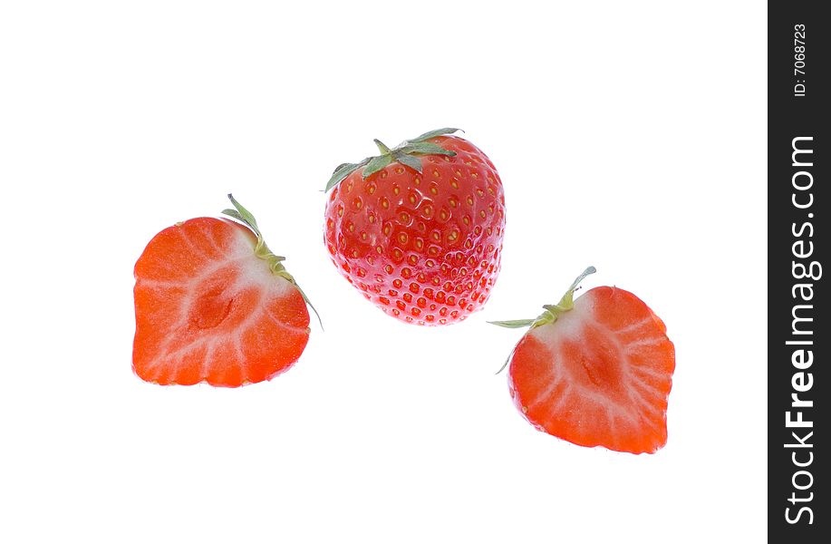 Three strawberries (two cut) on the white background