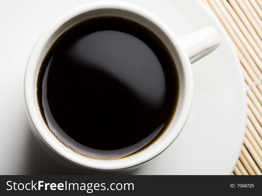 White cup of coffee over bamboo background