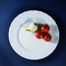 Tomatoes And Garlic In White Plate On Blue Background Royalty Free Stock Photography Tomatoes And Garlic In White Plate On Blue Background Royalty Free Stock Photography