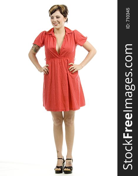 young woman with tattoos, a red goofy dress and a girlish expression poses different postures at an audition. young woman with tattoos, a red goofy dress and a girlish expression poses different postures at an audition