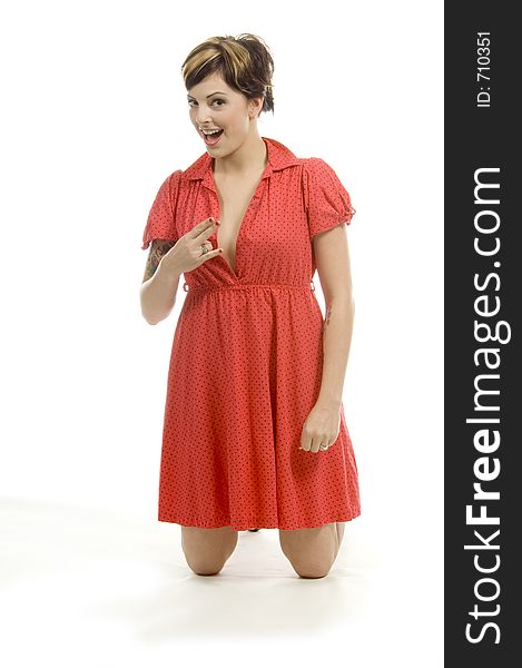 young woman with tattoos, a red goofy dress and a girlish expression poses different postures at an audition. young woman with tattoos, a red goofy dress and a girlish expression poses different postures at an audition