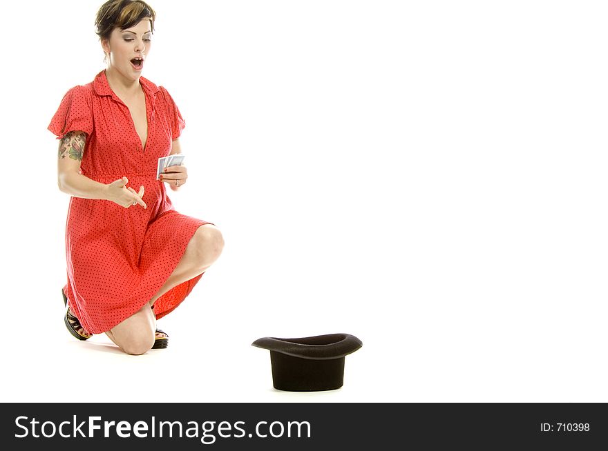 young actress with tattoos, a red girlish dress, poses different postures and expressions for an audition, with playing cards and a big black hat, over a white background. young actress with tattoos, a red girlish dress, poses different postures and expressions for an audition, with playing cards and a big black hat, over a white background