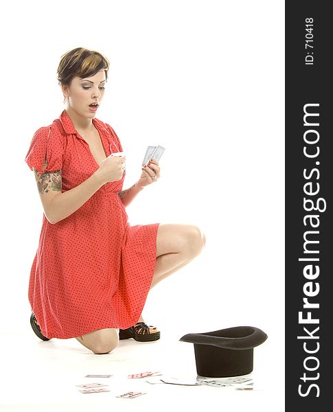 young actress with tattoos, a red girlish dress, poses different postures and expressions for an audition, with playing cards and a big black hat, over a white background. young actress with tattoos, a red girlish dress, poses different postures and expressions for an audition, with playing cards and a big black hat, over a white background