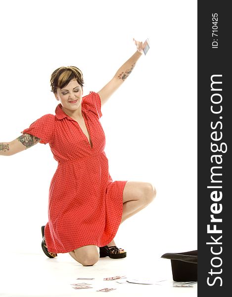 young actress with tattoos, a red girlish dress, poses different postures and expressions for an audition, with playing cards and a big black hat, over a white background. young actress with tattoos, a red girlish dress, poses different postures and expressions for an audition, with playing cards and a big black hat, over a white background