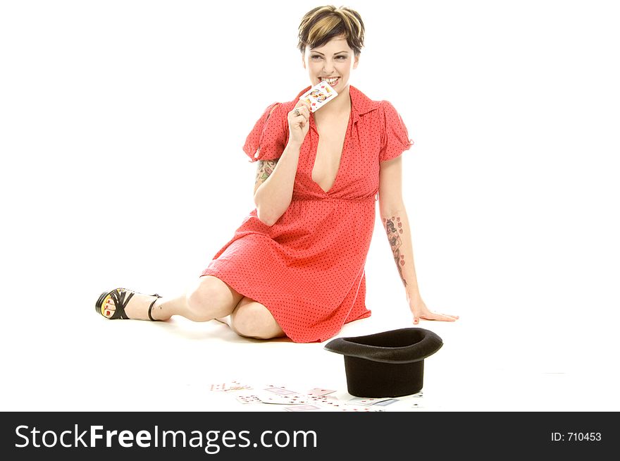 young actress with tattoos, a red girlish dress, poses different postures and expressions for an audition, with playing cards and a big black hat, over a white background. young actress with tattoos, a red girlish dress, poses different postures and expressions for an audition, with playing cards and a big black hat, over a white background