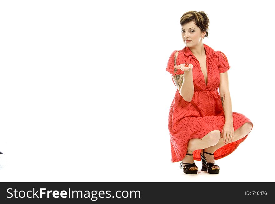 young actress with tattoos, a red girlish dress, poses different postures and expressions for an audition, playing with dices, down on the white floor. young actress with tattoos, a red girlish dress, poses different postures and expressions for an audition, playing with dices, down on the white floor