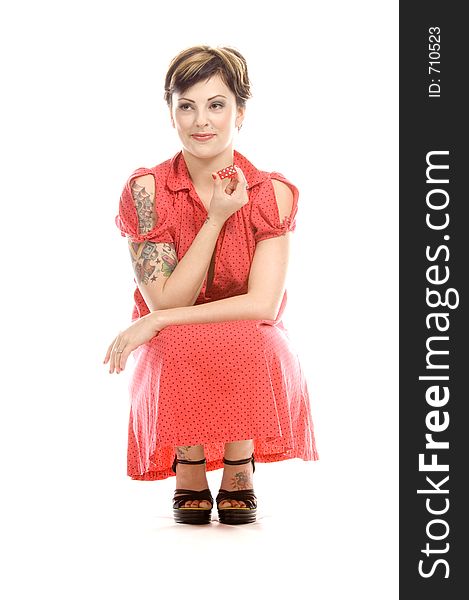 young actress with tattoos, a red girlish dress, poses different postures and expressions for an audition, playing with dices, down on the white floor. young actress with tattoos, a red girlish dress, poses different postures and expressions for an audition, playing with dices, down on the white floor