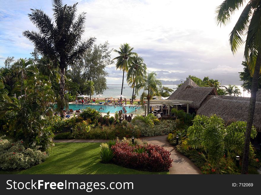Tropical ressort and pool with people and palm trees