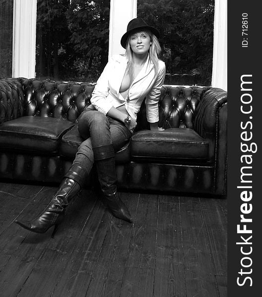 model wearing leather boots on a leather sofa. model wearing leather boots on a leather sofa