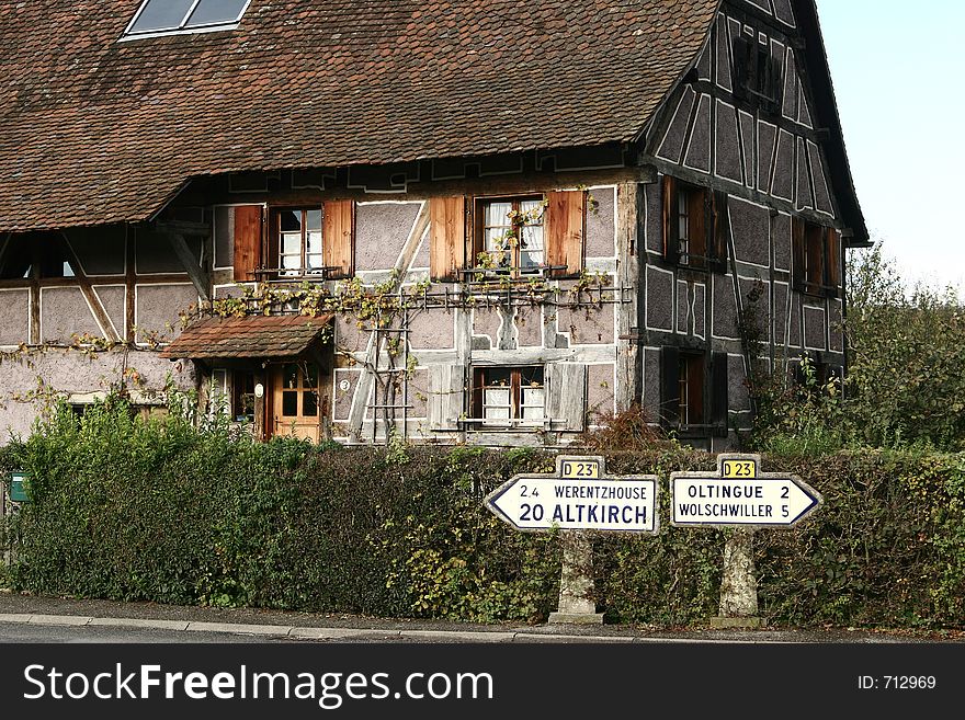 In the street of a alsacian villlage in the summer, signs with village names. In the street of a alsacian villlage in the summer, signs with village names