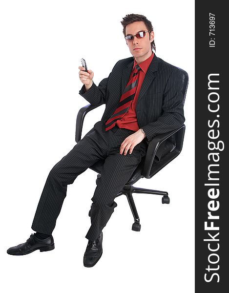 Businessman sits in chair holding a mobile phone and wearing cool shades