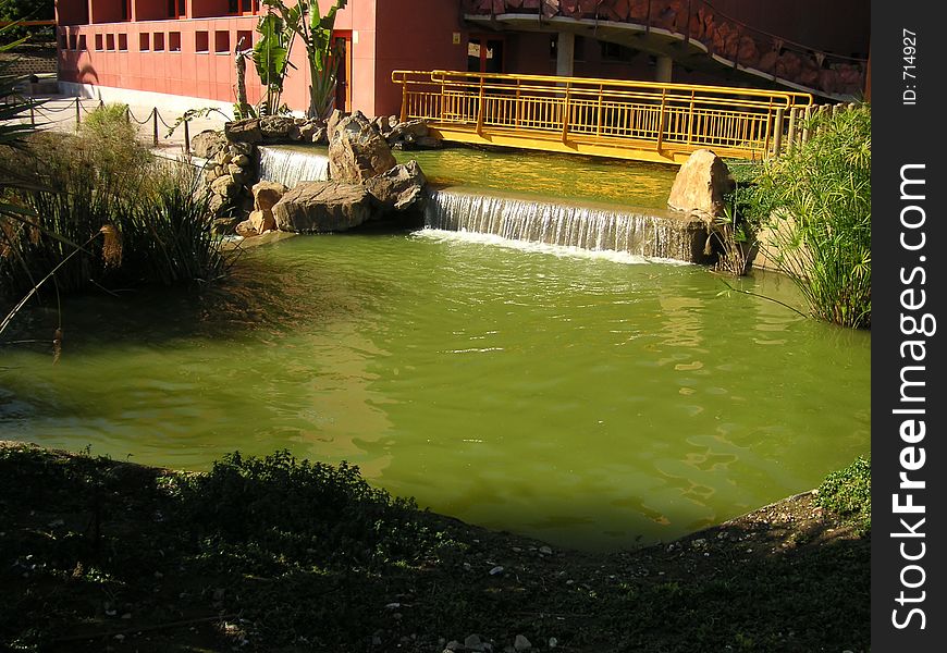 Bridge over a water fall of a pond. Bridge over a water fall of a pond